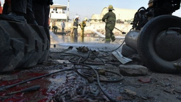 عمال إطفاء يعملون على إزالة بقايا تفجير في كابول في 28 كانون الأول/ديسمبر 2015 AFP